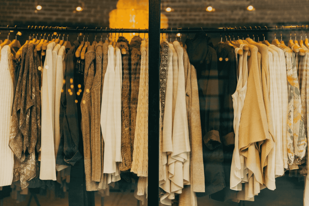 Neutral-coloured clothes on a clothing rack in a shop window